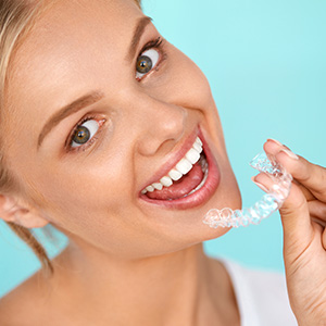 Woman holding Invisalign tray