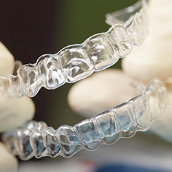 Hands holding set of Invisalign trays